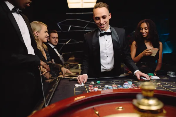 88FD — A high-class gaming experience without limits A woman in a luxurious green gown next to an ornate roulette wheel, capturing the upscale casino mood of 88FD.